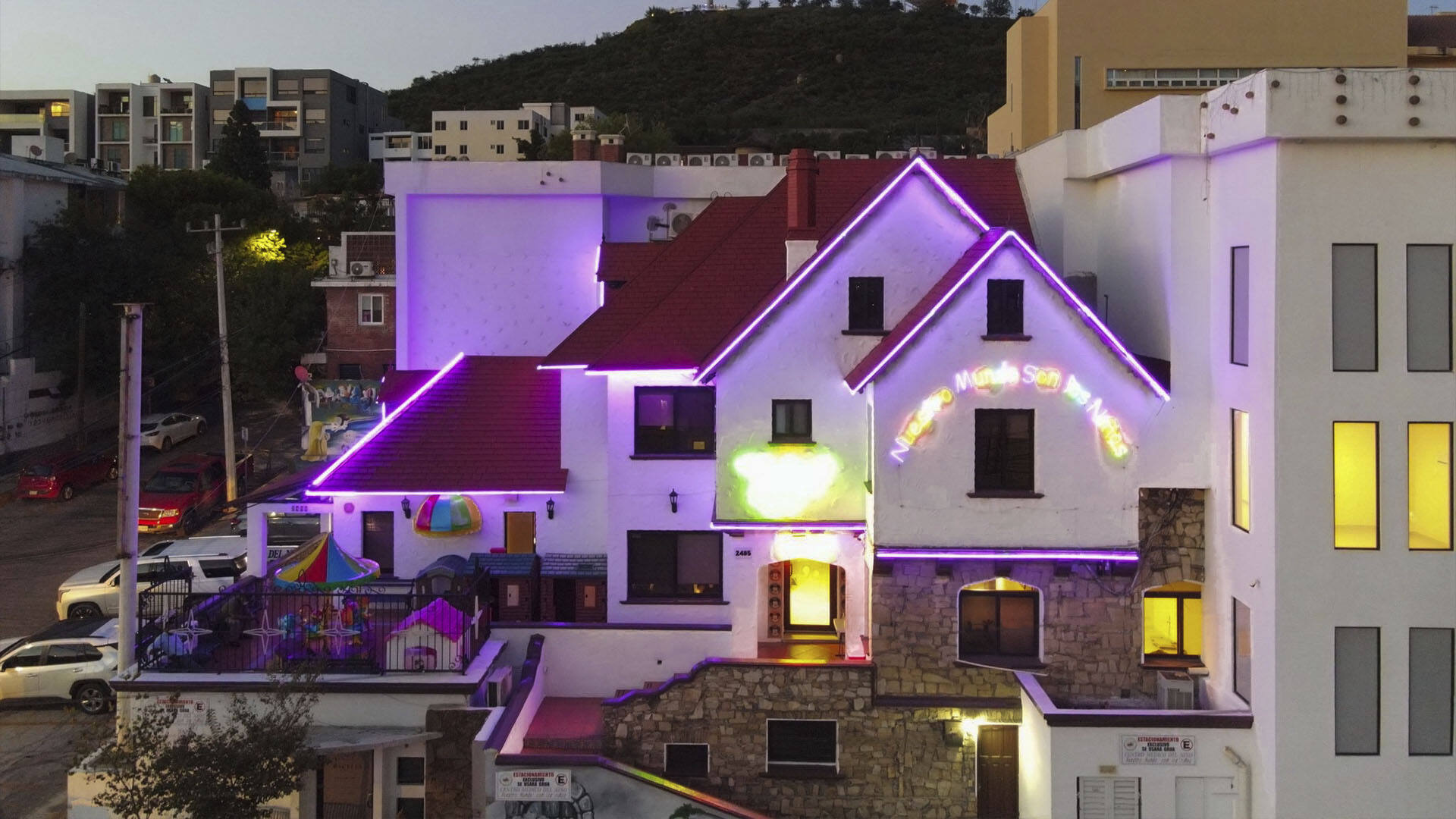 El Centro Médico del Niño de noche: la casa de techos rojos con las orillas iluminadas en morado, sobre Belisario Domínguez